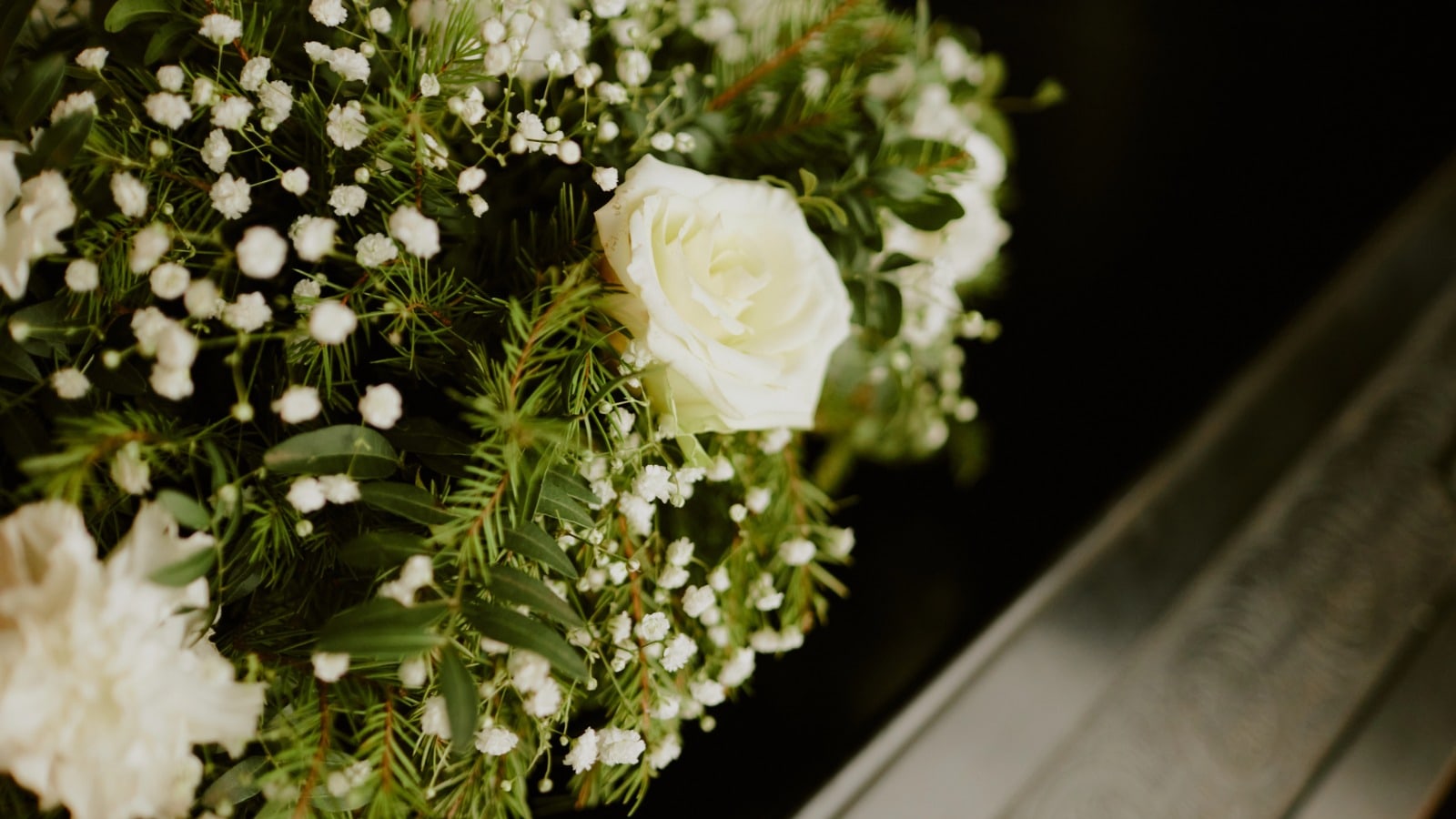 Rose bianche e gypsophila in una composizione di commiato