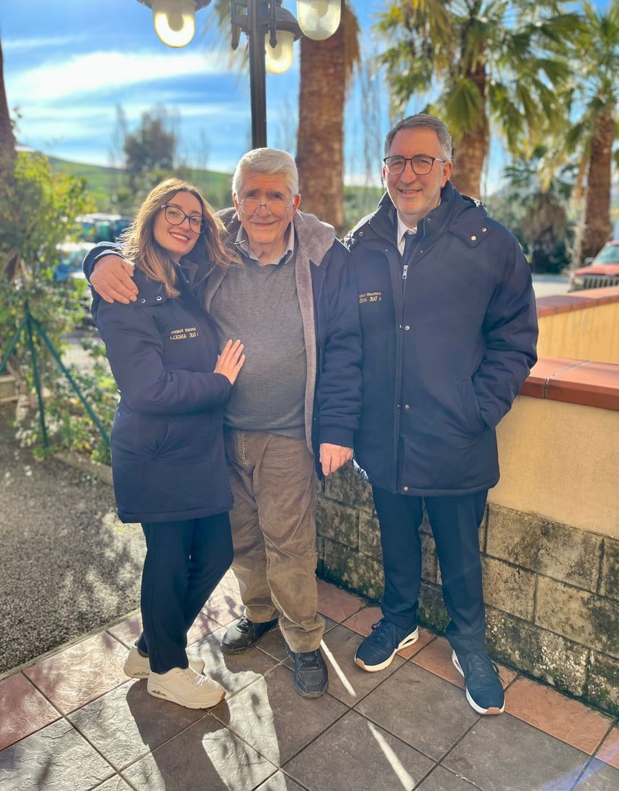 Emily e Giuseppe Carta insieme a un familiare davanti alla sede dell'agenzia
