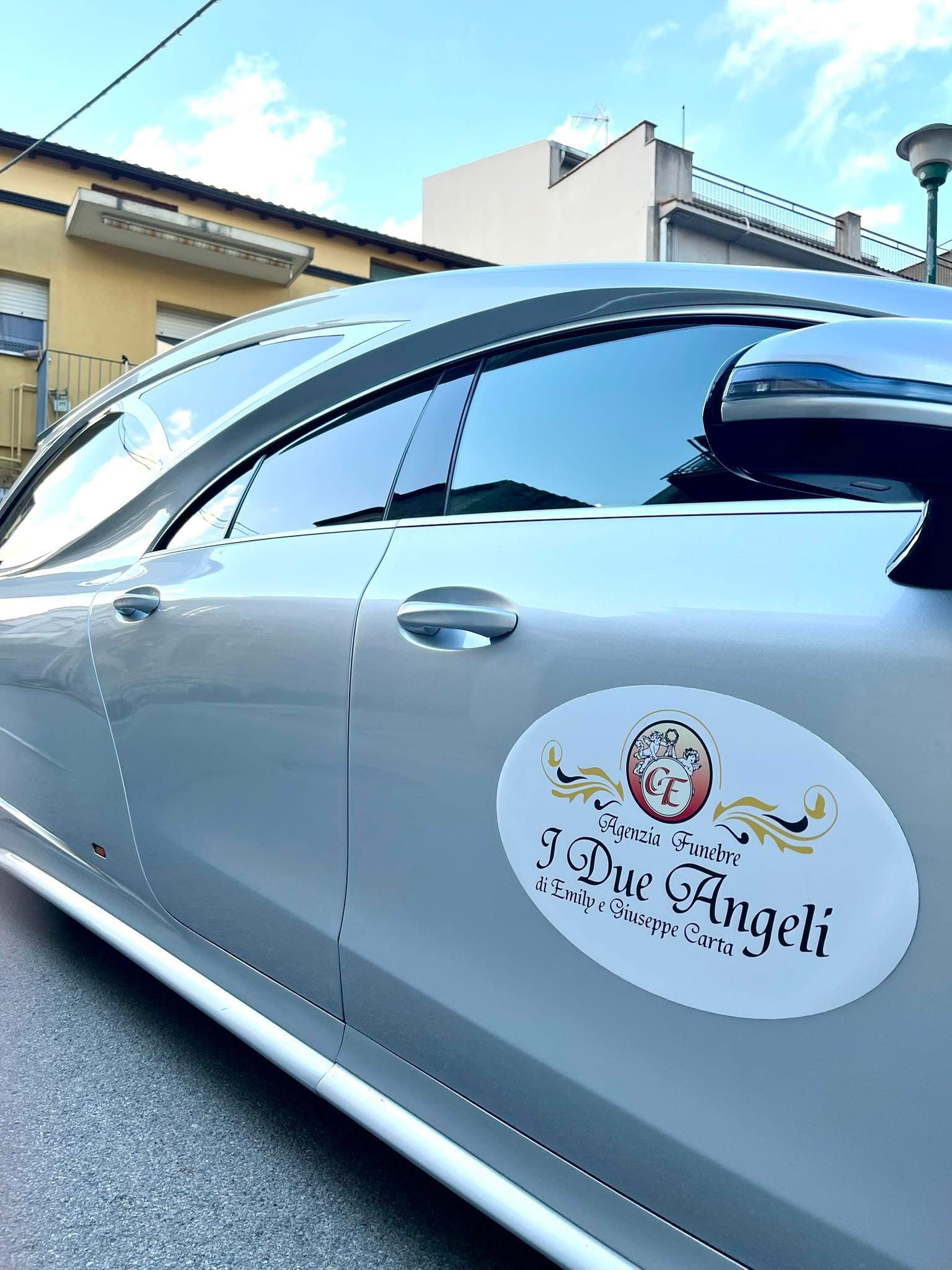 Lo stemma dell'Agenzia Funebre I Due Angeli sulla fiancata dell'auto di servizio