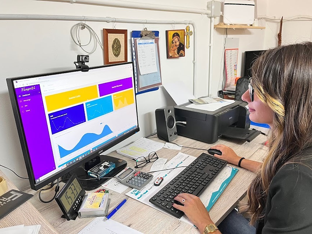 Emily Carta al lavoro in ufficio, davanti alla piattaforma dei necrologi
