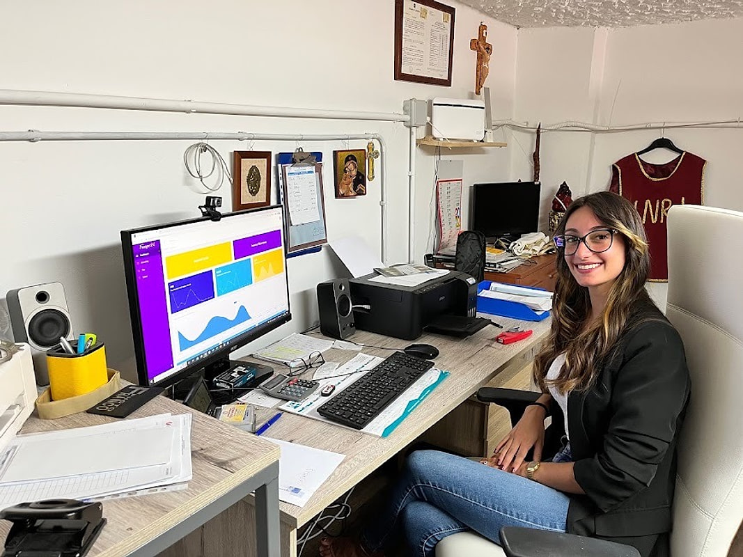 Emily Carta alla scrivania dell'ufficio dell'agenzia